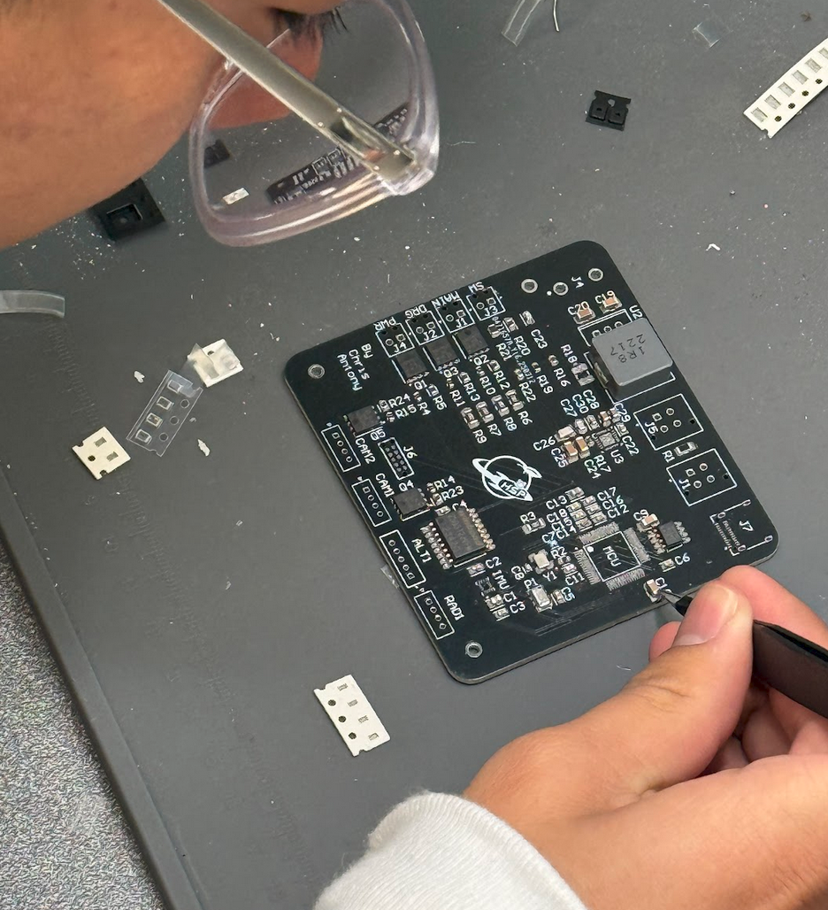 Emmanuel assembling a PCB by hand at the bench